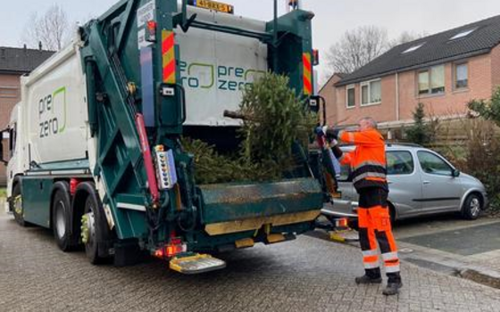 Medewerker van Prezero gooit een kerstboom in de vrachtwagen