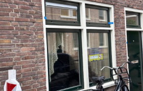 Bordje met de tekst 'Dit pand is gesloten' geplakt op het raam van een woning