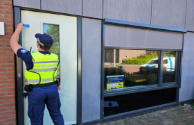 Handhaving plakt een verzegeling op de voordeur van een woning