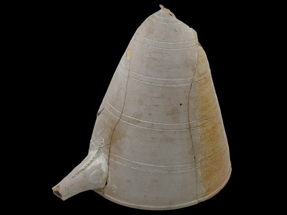 Een foto van de alambiek, ook wel destileerhelm genoemd. Het is een kegelvormig aardewerk voorwerp met een tuitje onderaan.