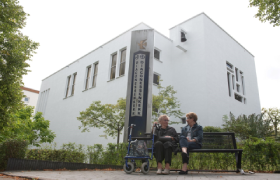 Twee dames van middelbare leeftijd zitten voor de Diaconessenkerk in Arnhem.