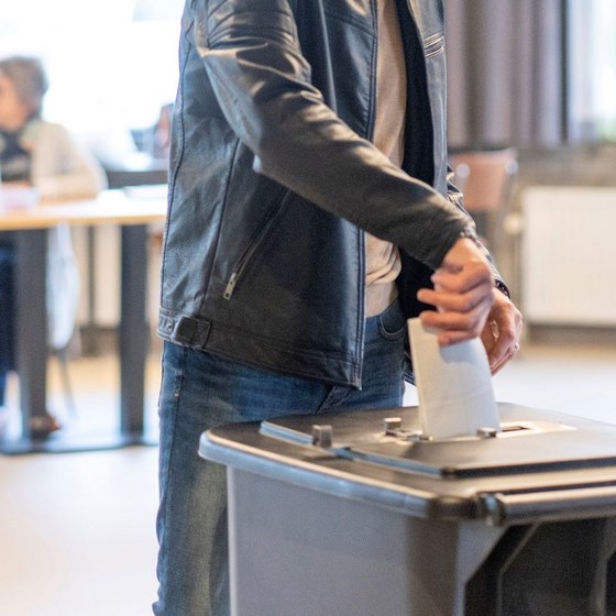 Iemand die een biljet in de stembus doet