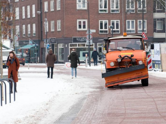 Strooiwagen strooit zout op fietspad