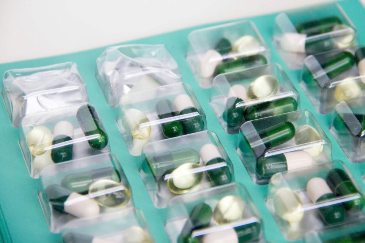 Een pillendoosje gevuld met groene en witte pillen
