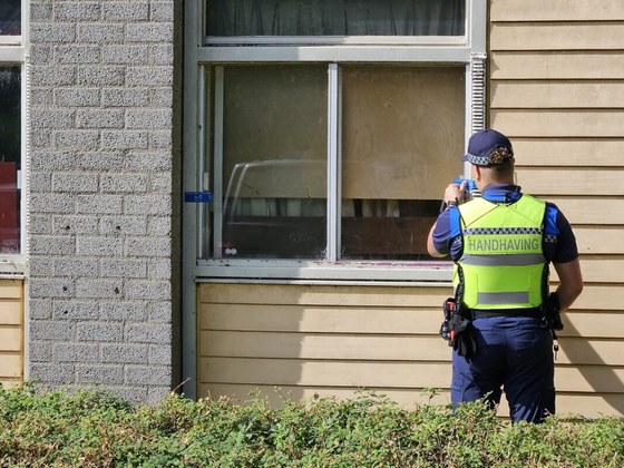 Een handhaver verzegelt de woning die tijdelijk wordt gesloten.
