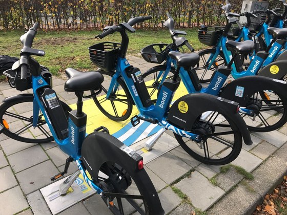 Elektrische deelfietsen die worden opgeladen via een stoeptegel