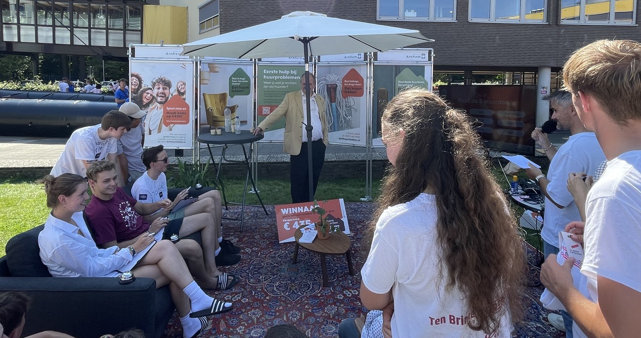 Studenten zitten op een bank en doen mee met een quiz tijdens de kick-off huurderscampagne op Hogeschool Arnhem en Nijmegen.