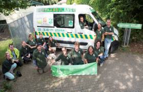 medewerkers van de dierenambulance zitten en staan voor een ambulancebus