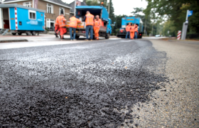 Wegwerkers leggen nieuw asfalt.