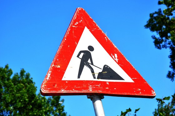 Een driehoekig verkeersbord met daarop een afbeelding van een persoon met een schep.