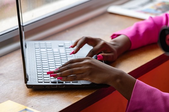 Vrouwenhanden tikken op het toetsenbord van een laptop.