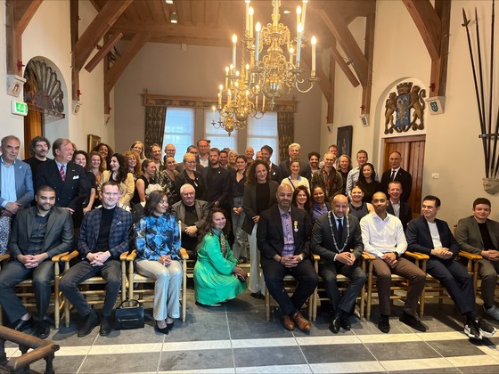 Alvin Williams poseert met een groep genodigden nadat hij is benoemd tot Ridder in de Orde van Oranje-Nassau