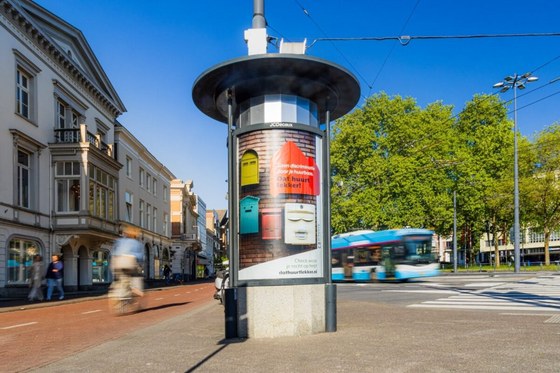 Een zuil op het Willemsplein in Arnhem. Op de zuil hangt een poster met de tekst 'Dat huurt lekker!'
