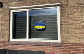 Bordje met de tekst 'Dit pand is gesloten' geplakt op het raam van een woning
