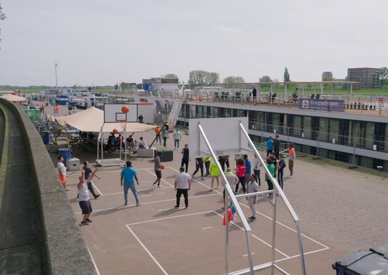 Vluchtelingen spelen basketbal op de sportboulevard aan de Nieuwe Kade.