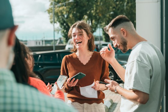 Een man en een vrouw lachen terwijl ze met andere mensen in gesprek zijn.