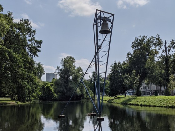 De Burgerklok. De klok hangt in een blauwe stellage die in het water staat.